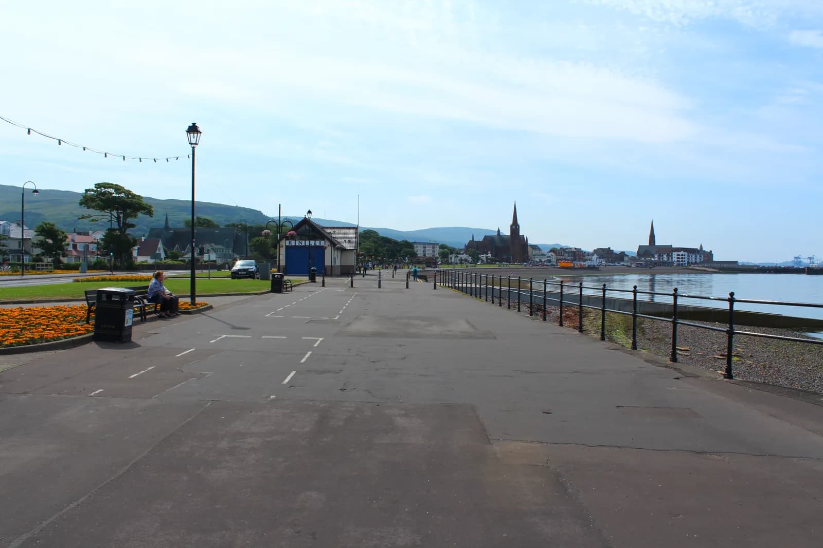 The promenade at Largs on a summer day, with flower beds, church spires and the Firth of Clyde