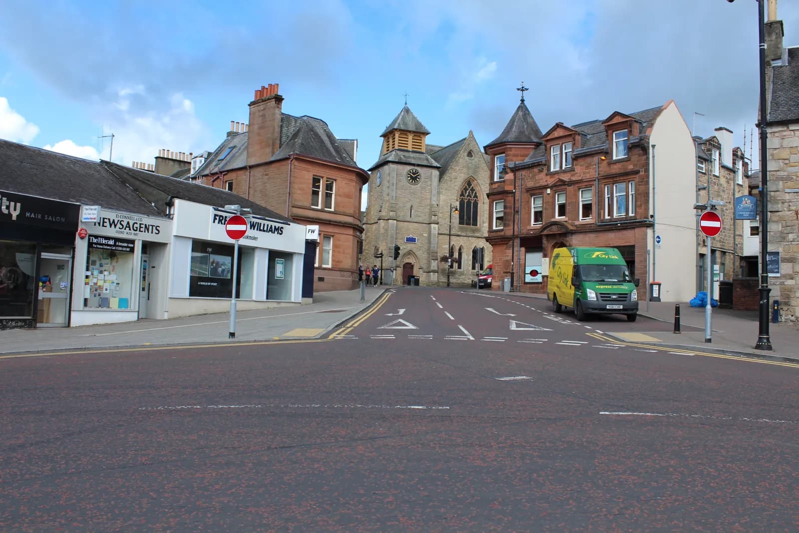 Glaisnock Street in Cumnock town centre, looking towards a clock-towered church and red sandstone buildings